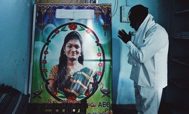 Pai de Kirni Mounika diante de um retrato dela